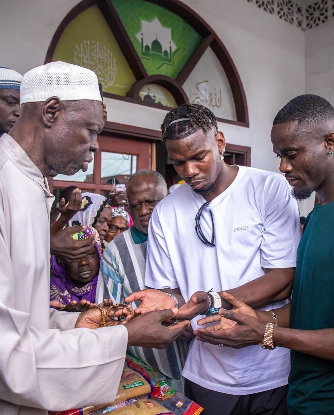 Pogba and Bailly  receiving blessing from an elder