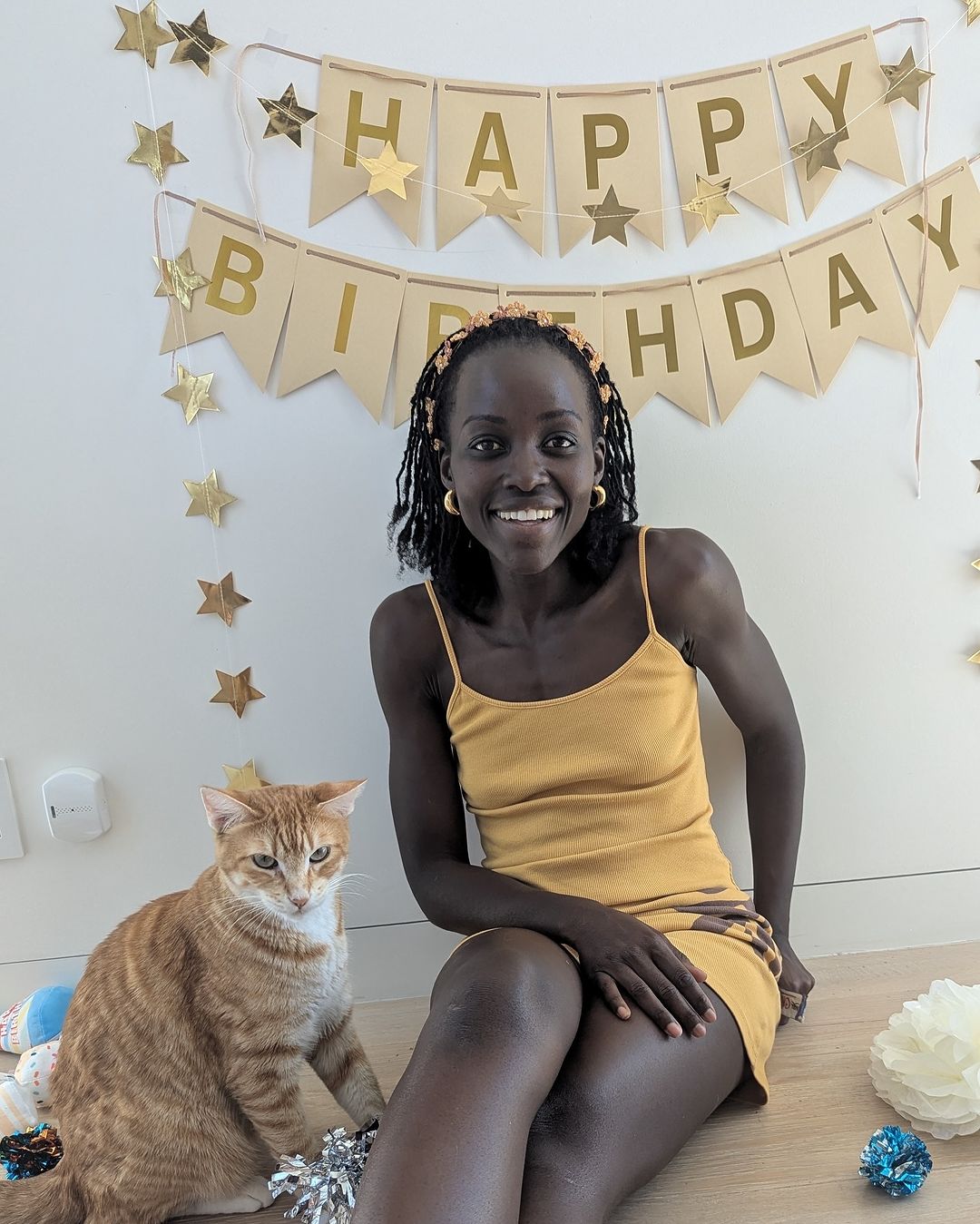 Lupita Nyong'o with her cat Yoyo celebrating 