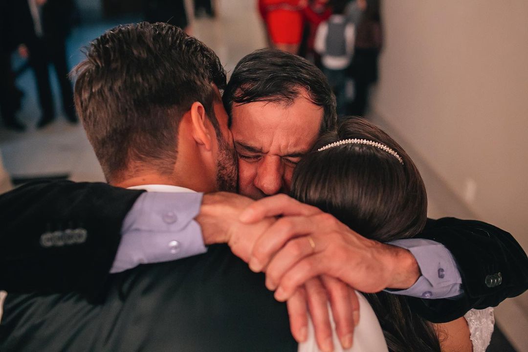 Alisson Becker with his father Jose Agostinho Becker hugging him  and  his wife on their wedding