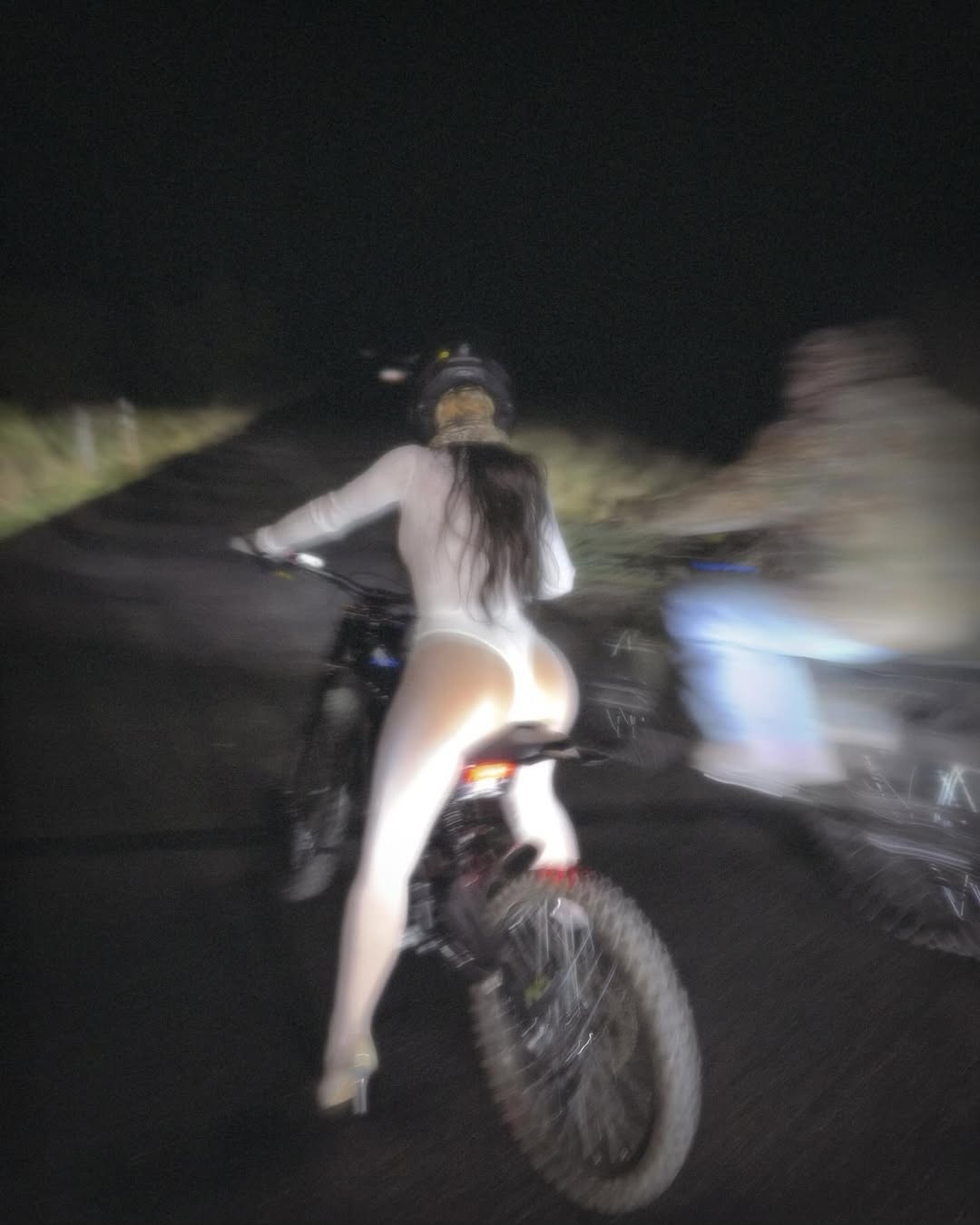 Kim Kardashian riding a bike in a see through  body suit 